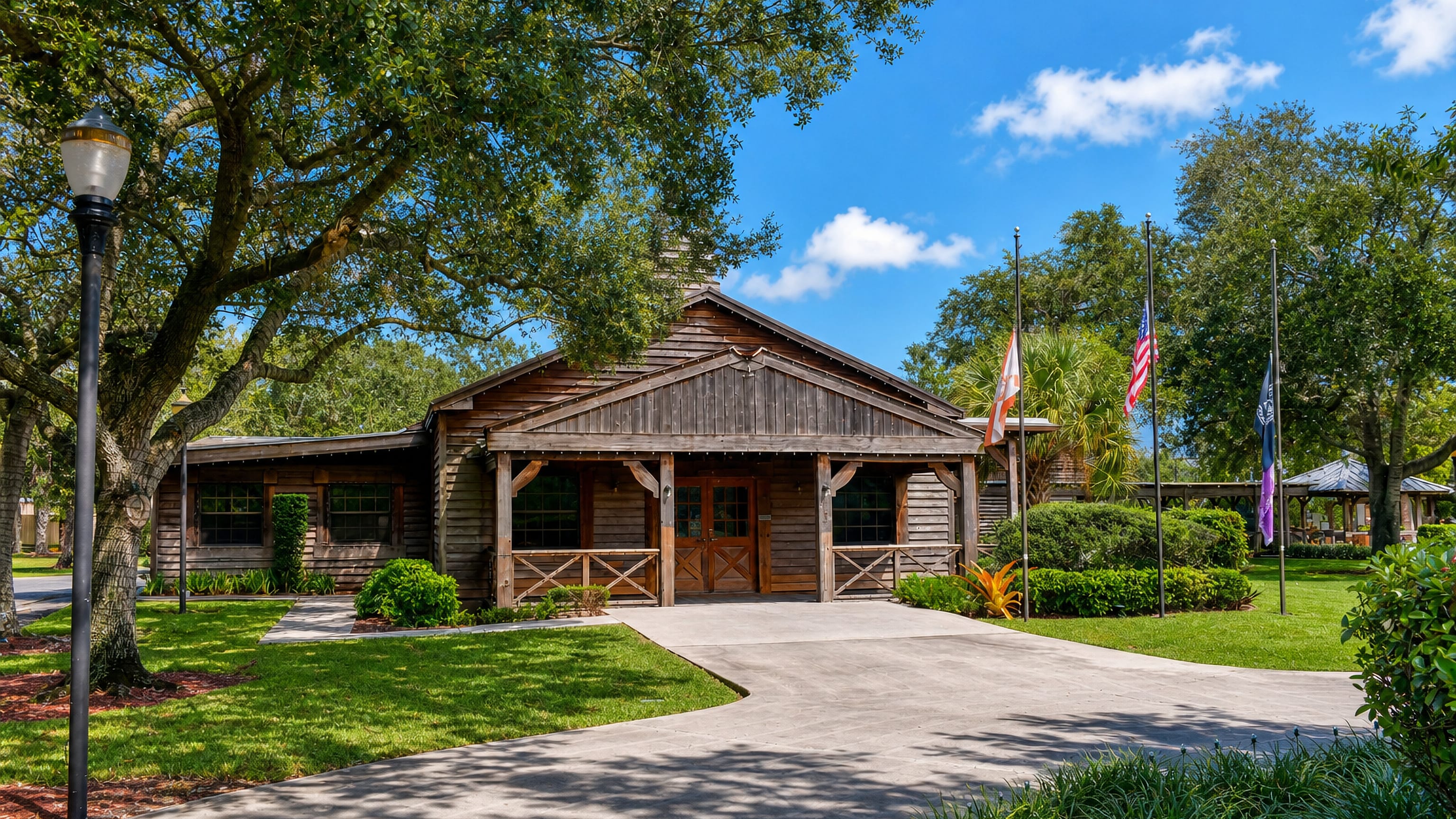 Rustic timber civic building with US and Florida flags under spreading live oaks in Davie, Florida