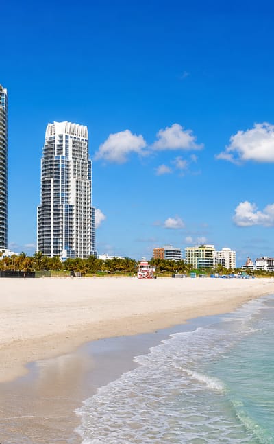 Miami Beach, Florida, with high-rise towers above South Pointe's white sand and turquoise Atlantic surf.
