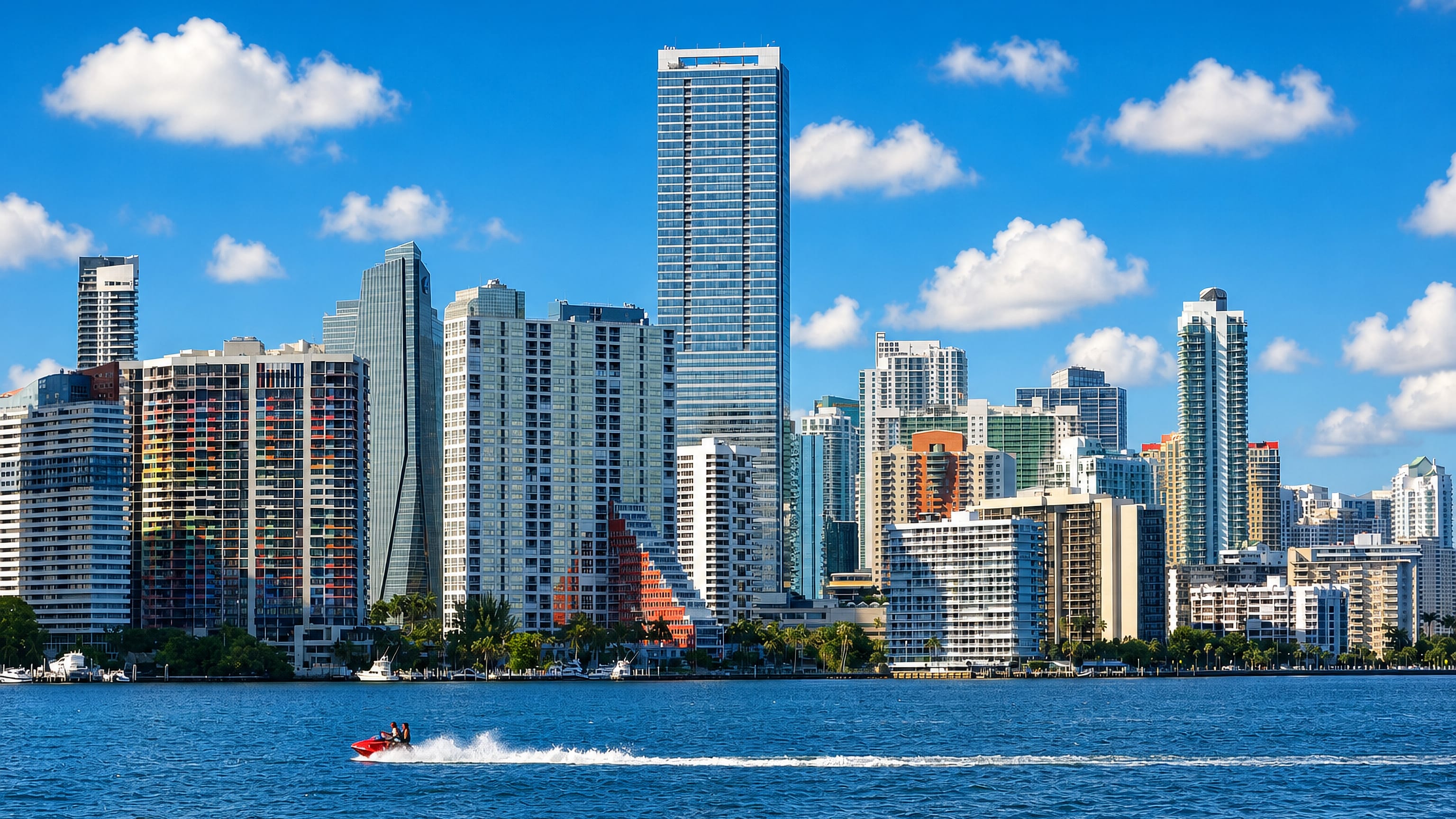Brickell's waterfront high-rises in Miami seen across Biscayne Bay as a jet ski crosses the water
