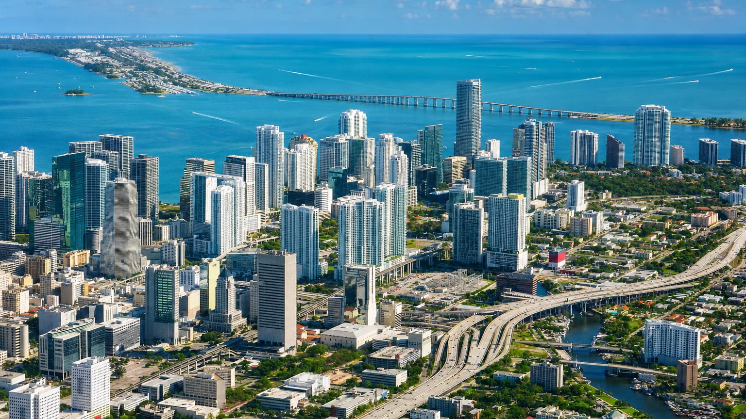 Aerial view of the Miami skyline with Brickell high-rises, Biscayne Bay, a causeway bridge and highway interchange