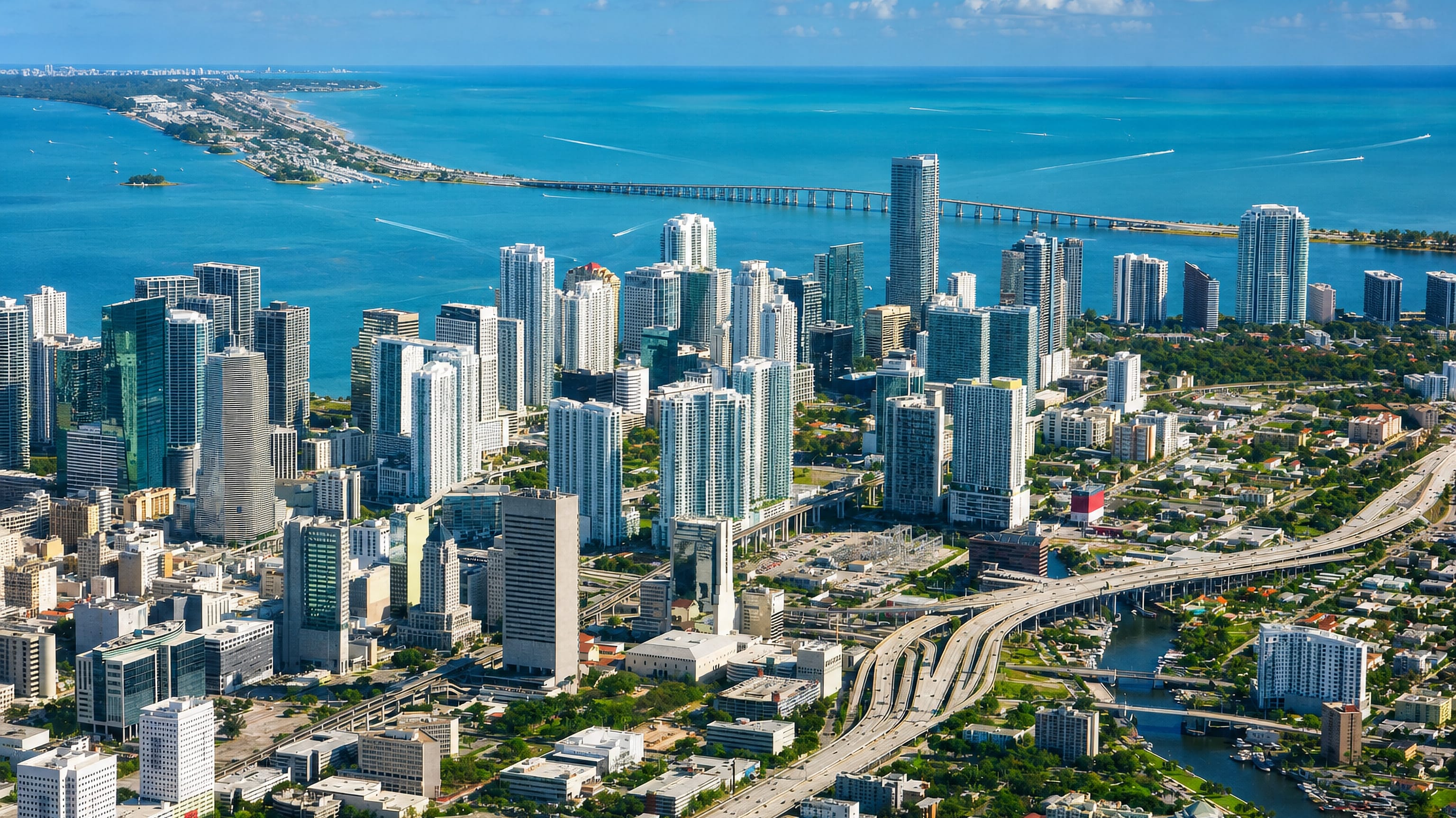 Aerial view of the Miami skyline with Brickell high-rises, Biscayne Bay, a causeway bridge and highway interchange