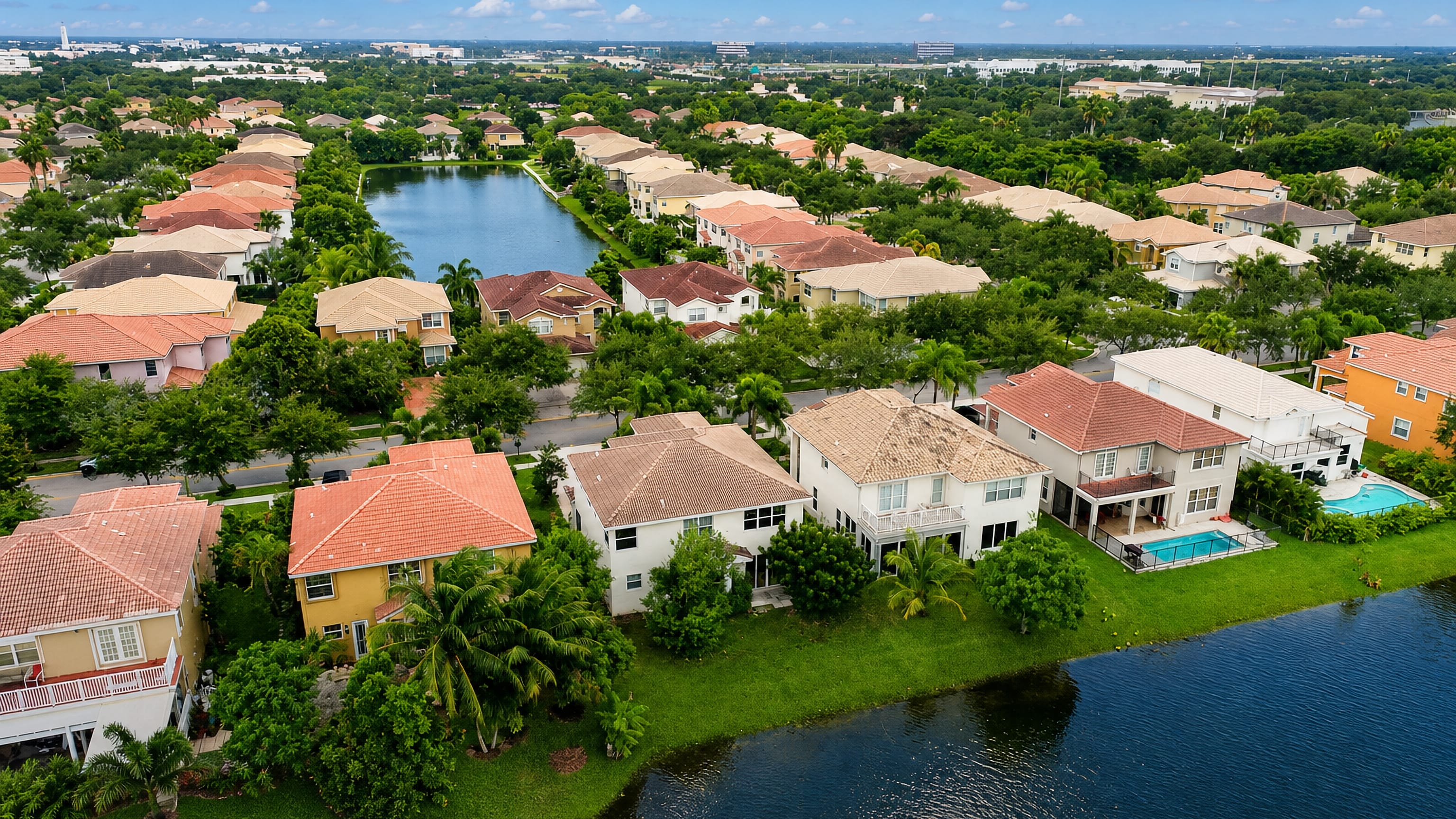 Aerial view of Miramar, Florida: tile-roofed lakeside homes, palms and green suburban streets.