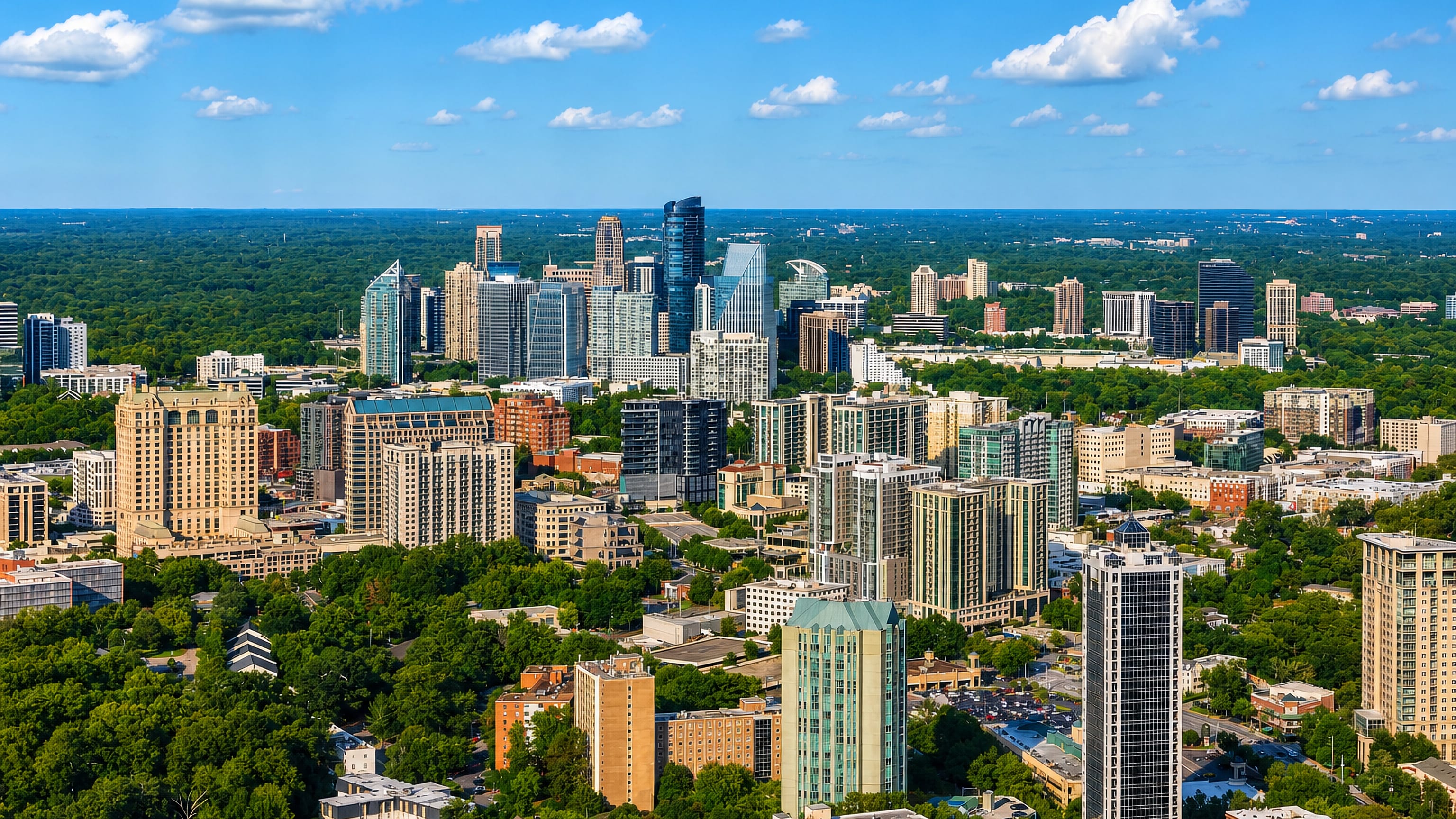 Buckhead's high-rise skyline rising from Atlanta's tree canopy on a clear day.