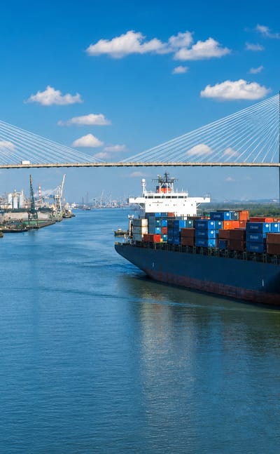 The Talmadge Memorial Bridge over the Savannah River with a container ship and a tall-ship replica.