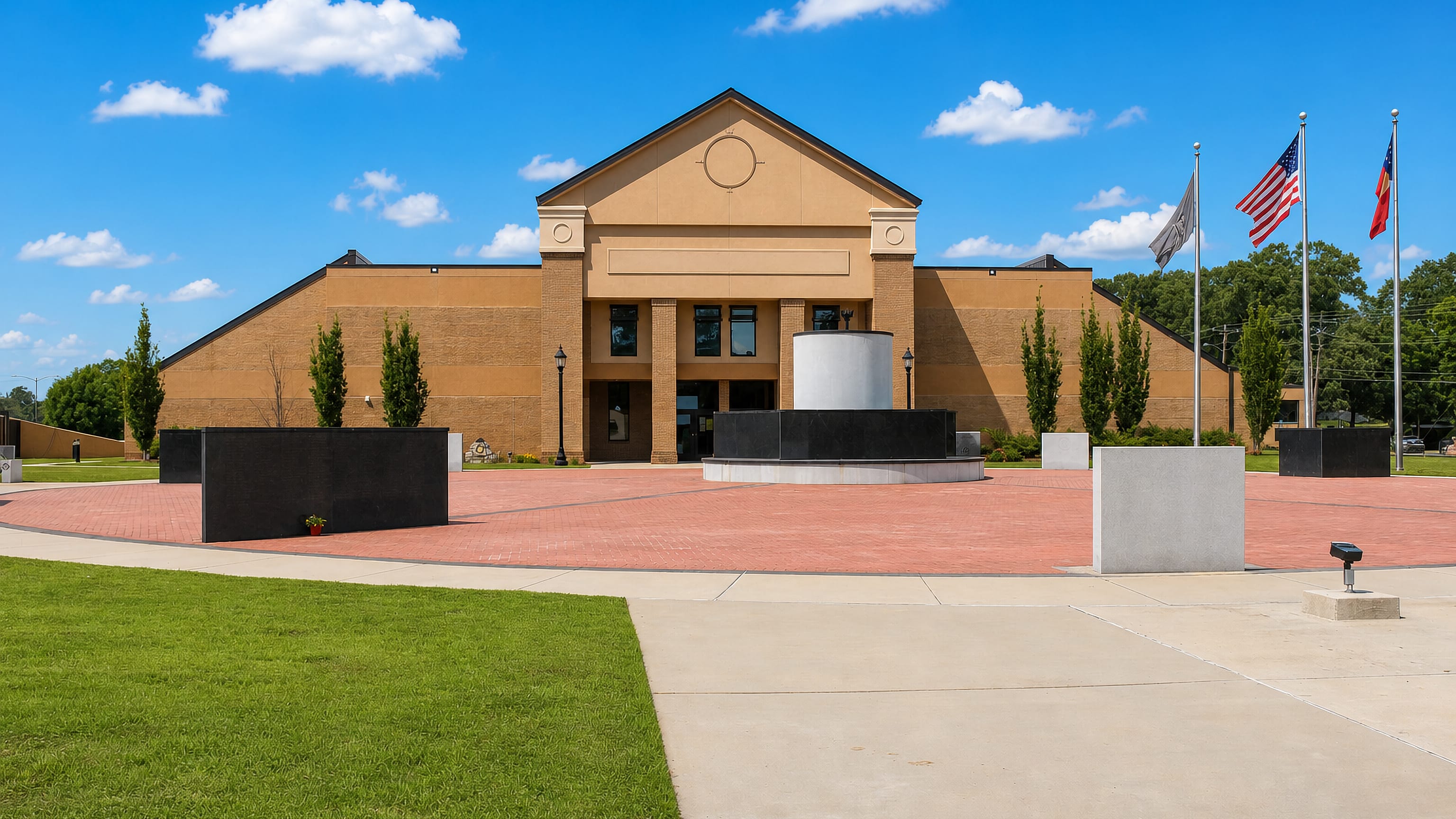 Flags and granite memorials on the brick plaza of a civic building in Warner Robins, Georgia.