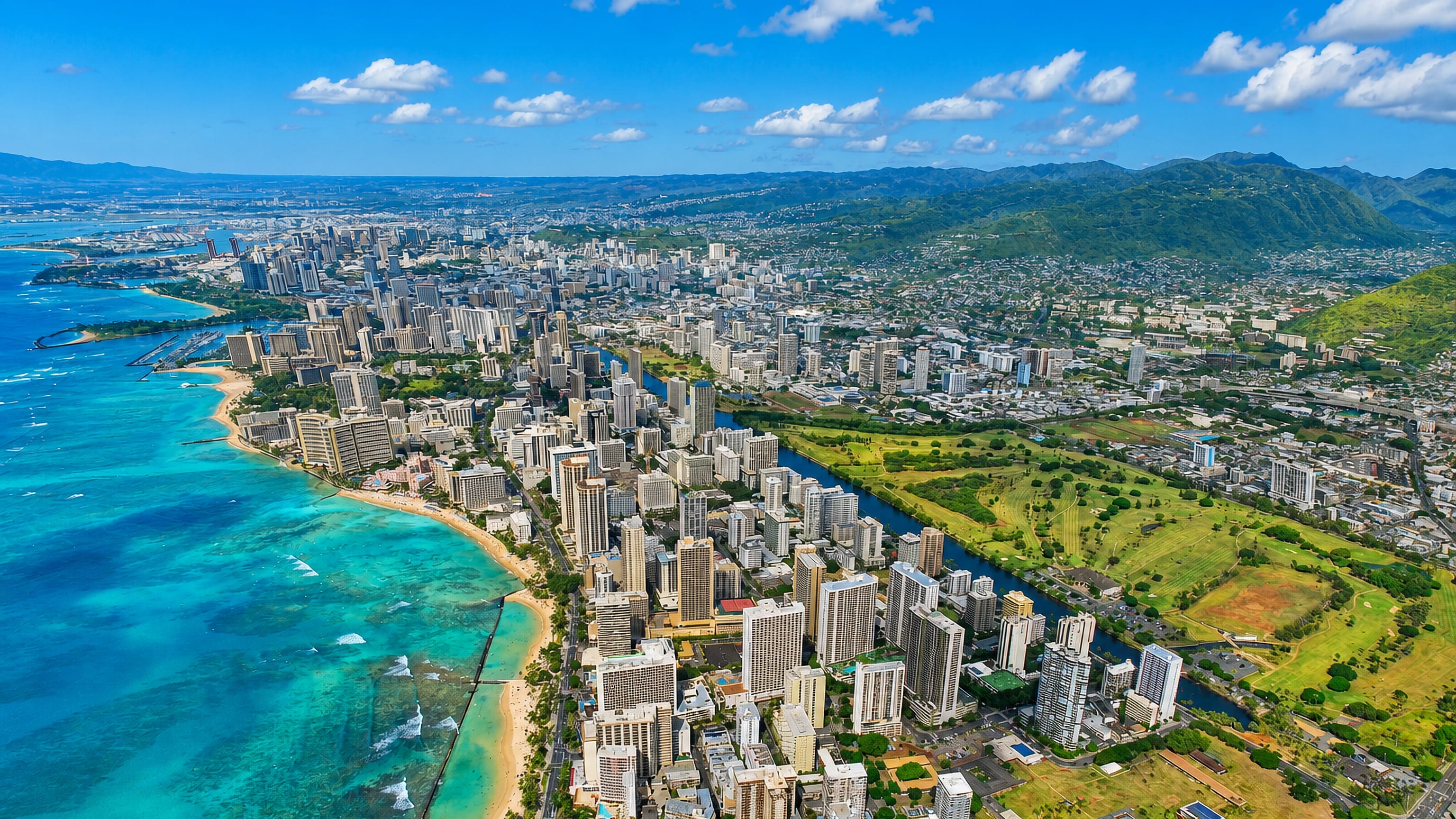 Aerial of Waikiki, Honolulu with beachfront high-rises, turquoise water and Diamond Head crater beyond.