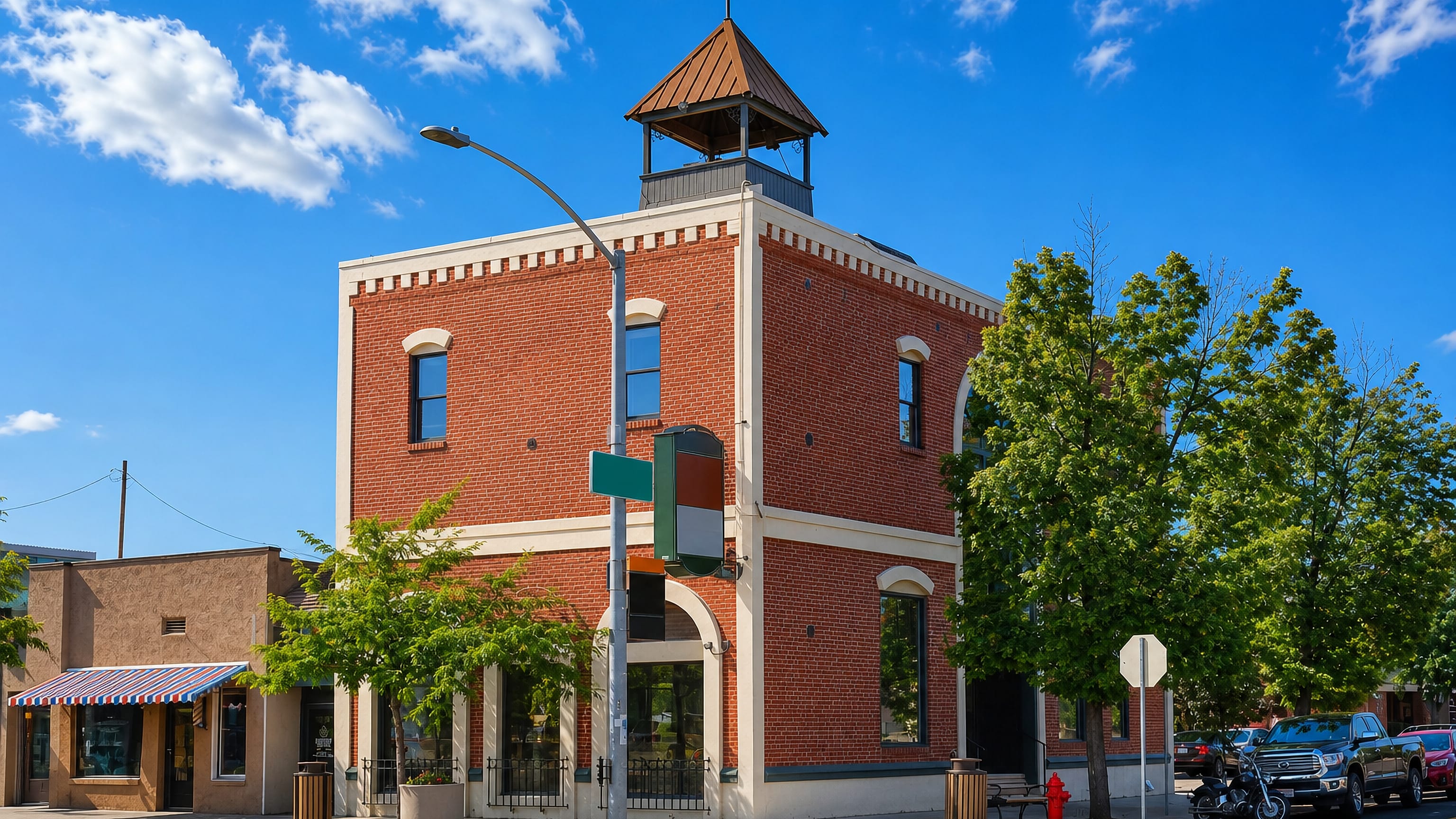 Historic brick corner building with a rooftop cupola on a downtown street in Meridian, Idaho
