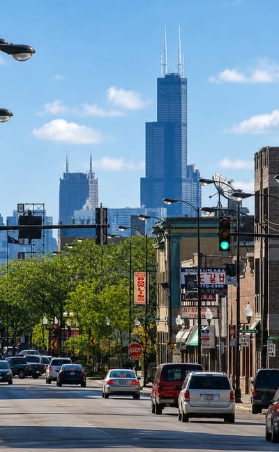 Chicago's Lincoln Square commercial street with Willis Tower and the skyline rising in the distance