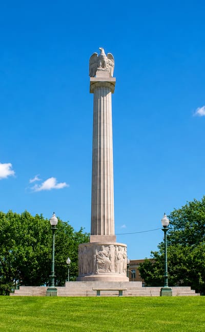 The eagle-topped Illinois Centennial Monument column on a green lawn in Logan Square, Chicago