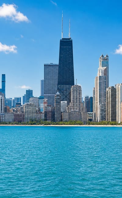 Chicago lakefront skyline with the John Hancock Center and Gold Coast high-rises above the blue water of Lake Michigan