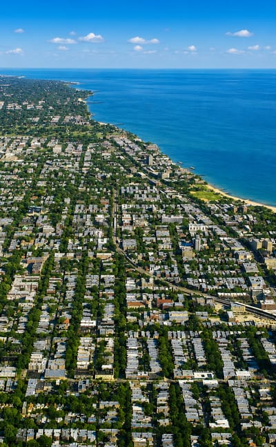 Aerial view of Rogers Park's gridded tree-lined residential streets along the Lake Michigan shoreline in Chicago
