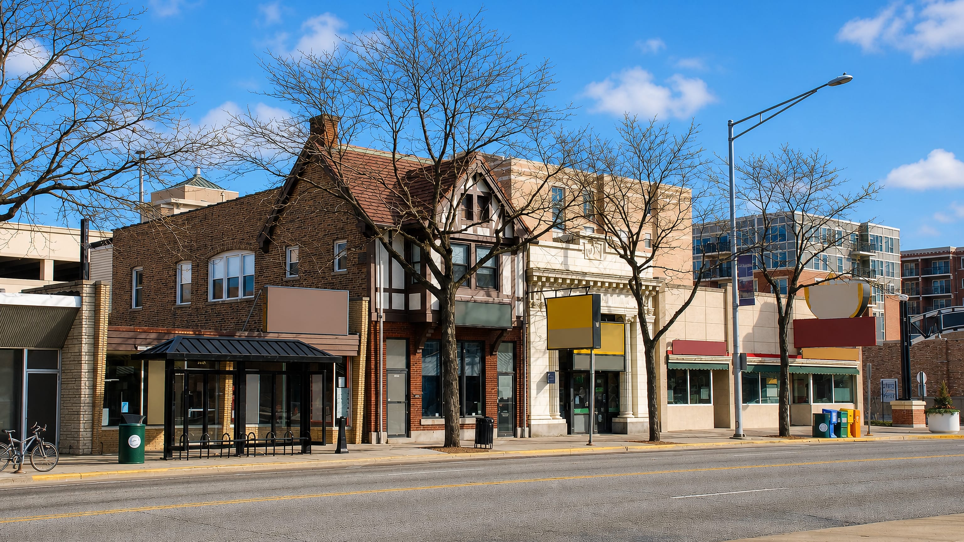 Low brick and half-timbered storefronts along a downtown street in Des Plaines, Illinois, on a clear day