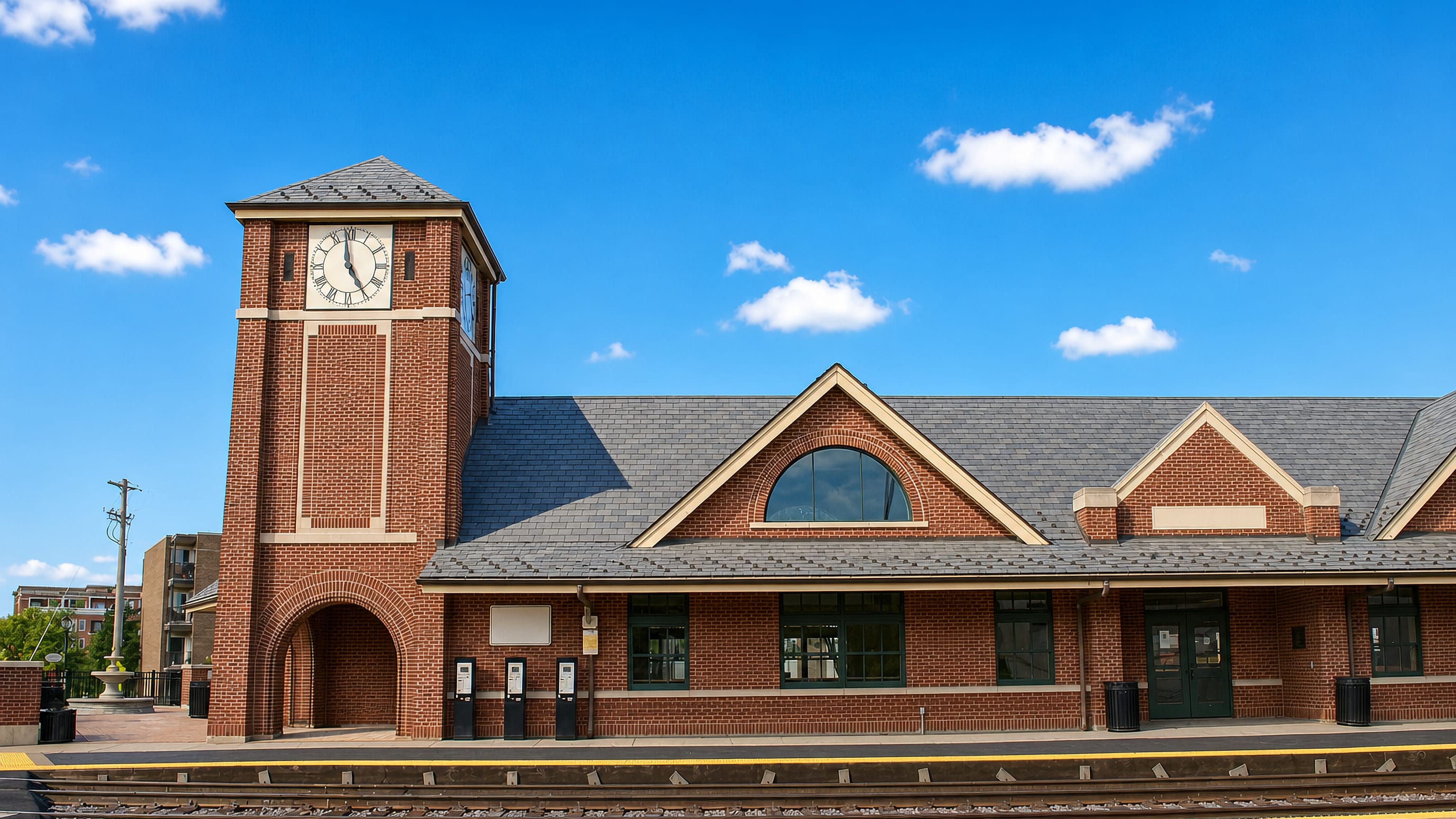 The brick commuter rail depot and clock tower beside the tracks in Palatine, Illinois.
