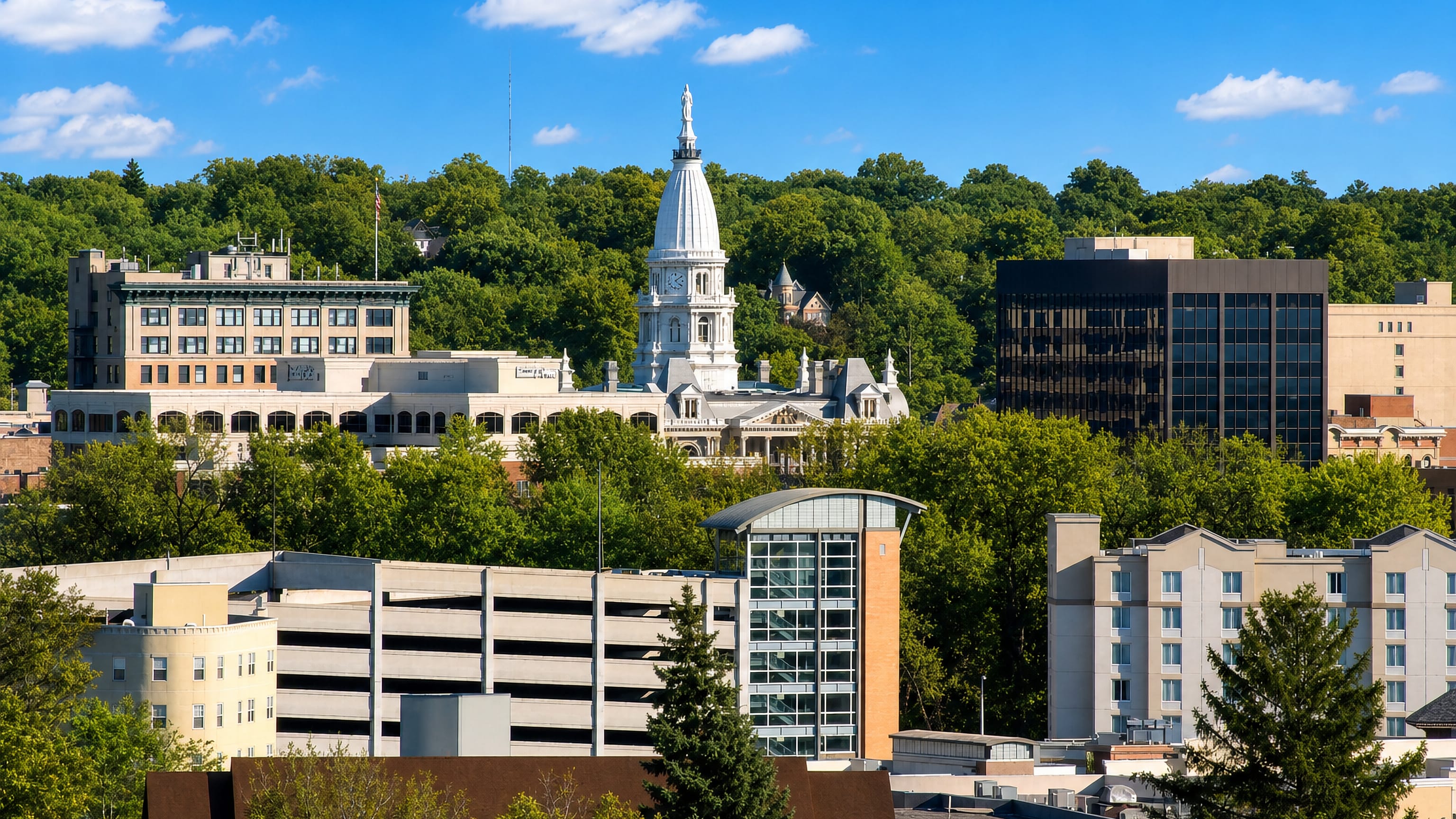 Downtown Lafayette, Indiana, with a white domed civic tower rising above wooded streets and low office blocks.