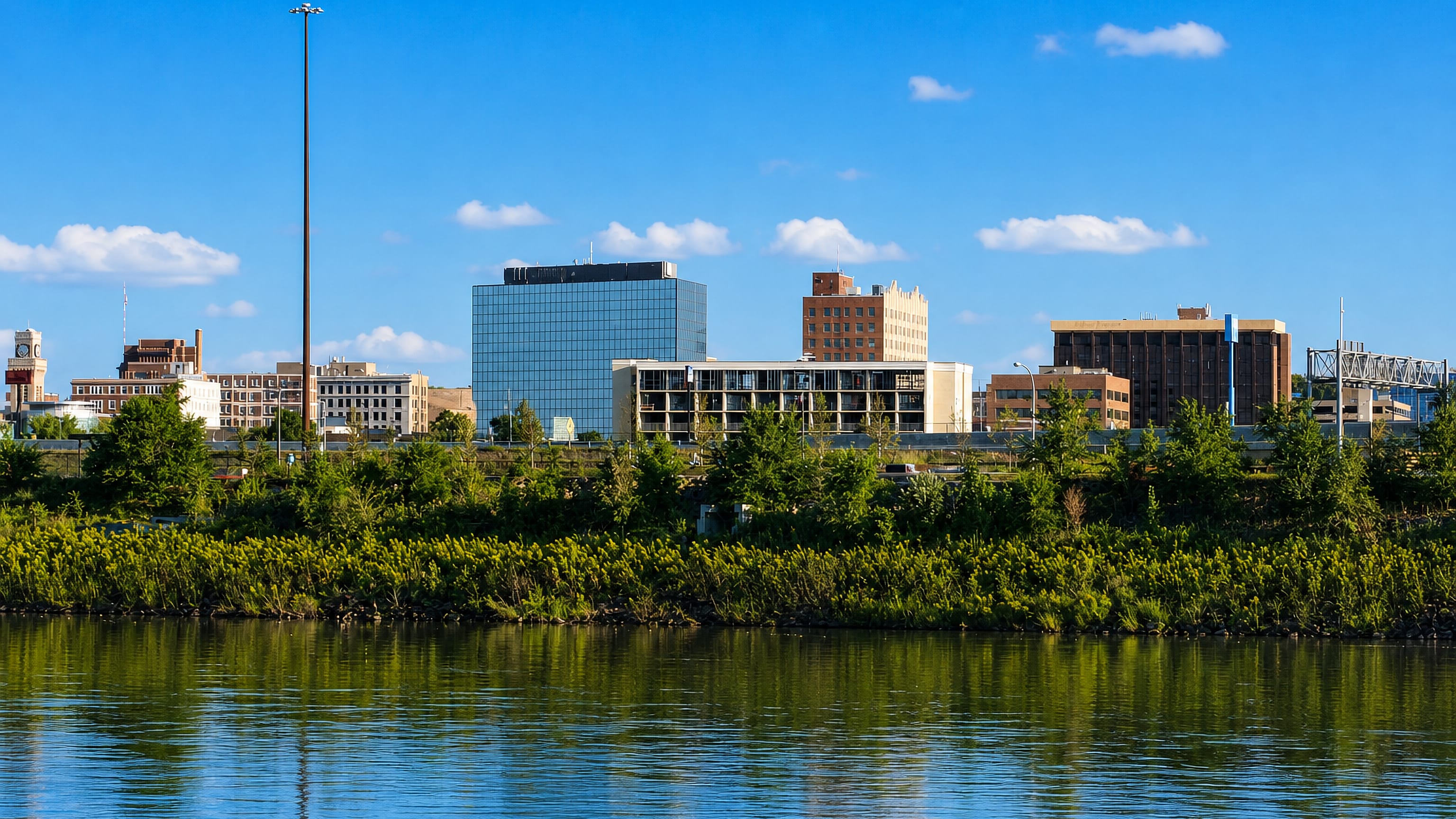 Low downtown skyline of Sioux City, Iowa, rising behind the wooded bank of the Missouri River.