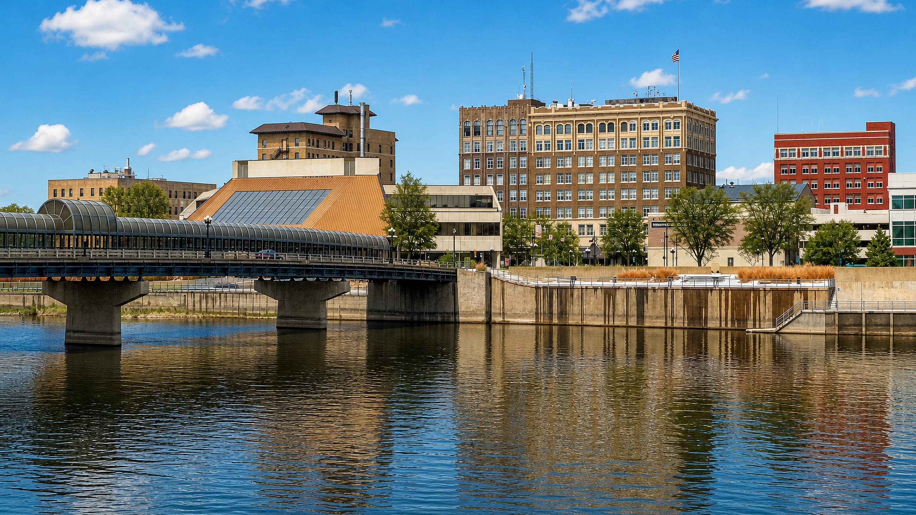 Downtown Waterloo, Iowa, along the Cedar River with a bridge, covered walkway and brick office blocks.