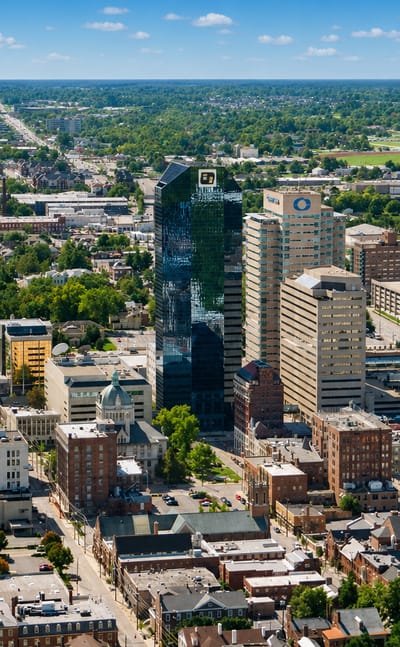 Aerial view of downtown Lexington, Kentucky with its dark-glass tower rising over the city center.
