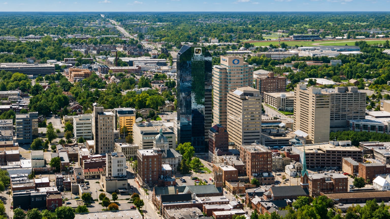 Aerial view of downtown Lexington, Kentucky with its dark-glass tower rising over the city center.