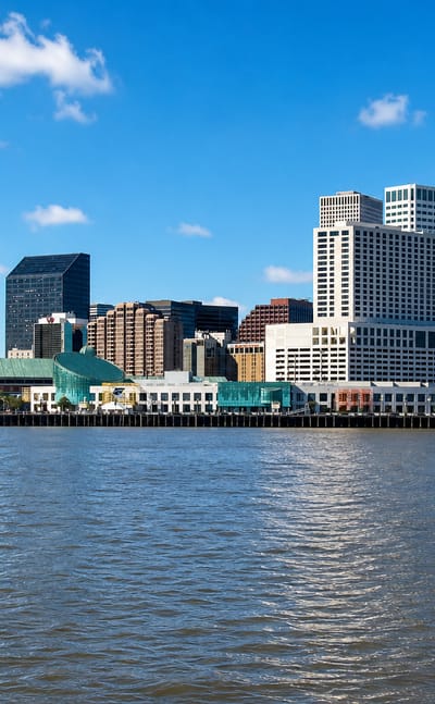 New Orleans central business district skyline seen across the Mississippi River with riverfront hotels.