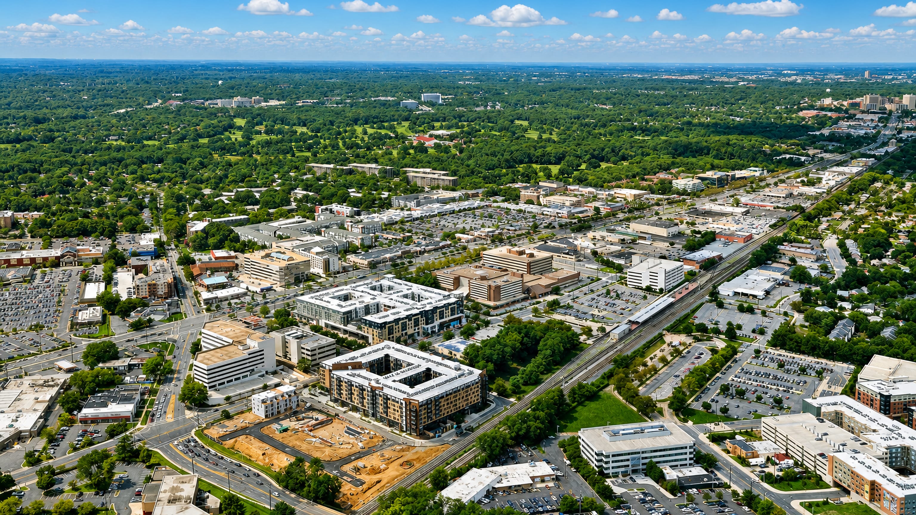 Aerial view over Rockville, Maryland, with mid-rise apartments, town-centre blocks and the rail line