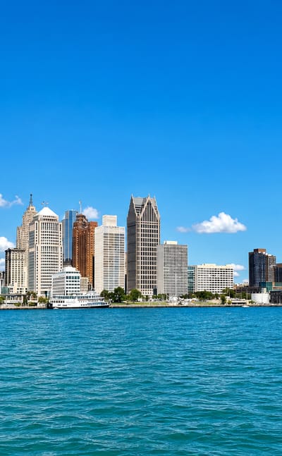 Detroit's downtown skyline across the Detroit River, anchored by the GM Renaissance Center towers.