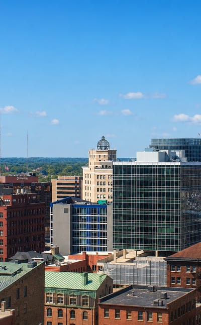 Downtown Grand Rapids, Michigan skyline of mid-rise office towers under a clear blue sky.