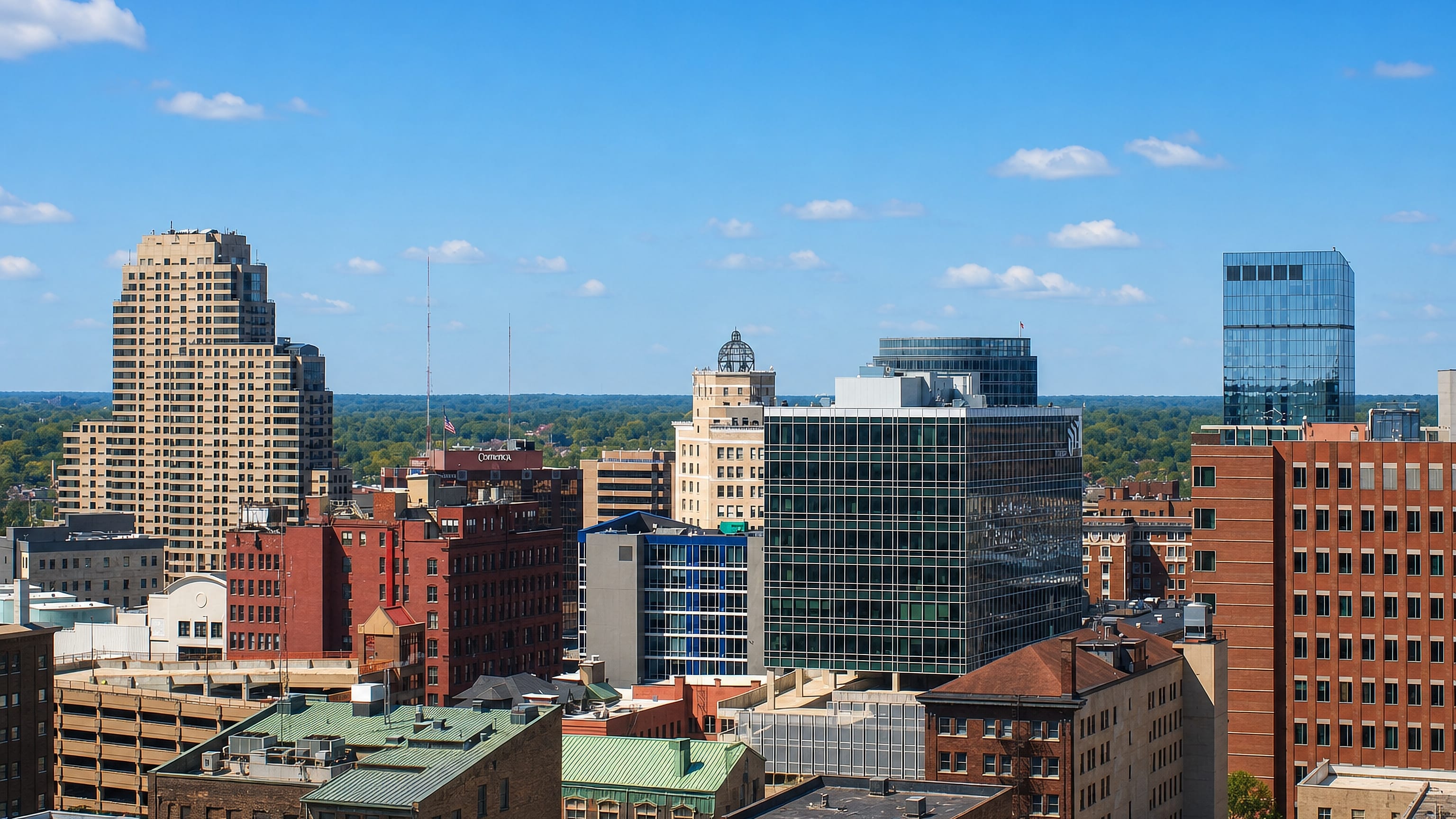 Downtown Grand Rapids, Michigan skyline of mid-rise office towers under a clear blue sky.