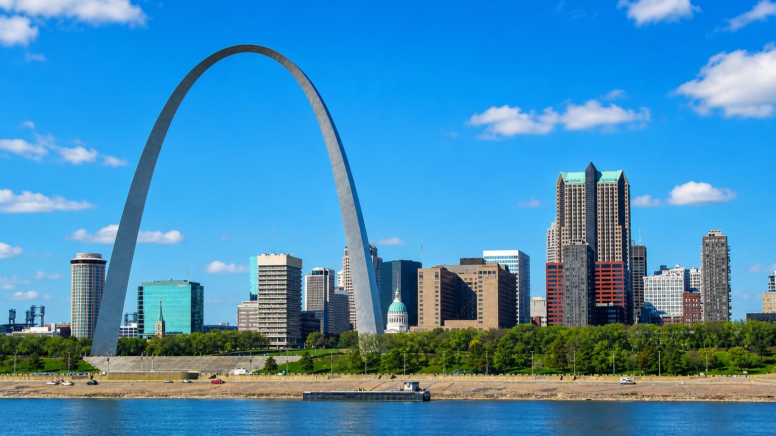 St. Louis Gateway Arch framing the downtown skyline and courthouse dome above the Mississippi riverfront.