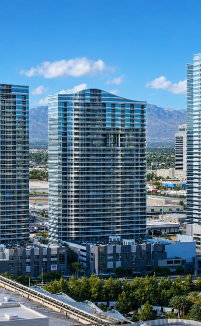 High-rise glass residential towers rising above Paradise, Nevada with desert mountains beyond