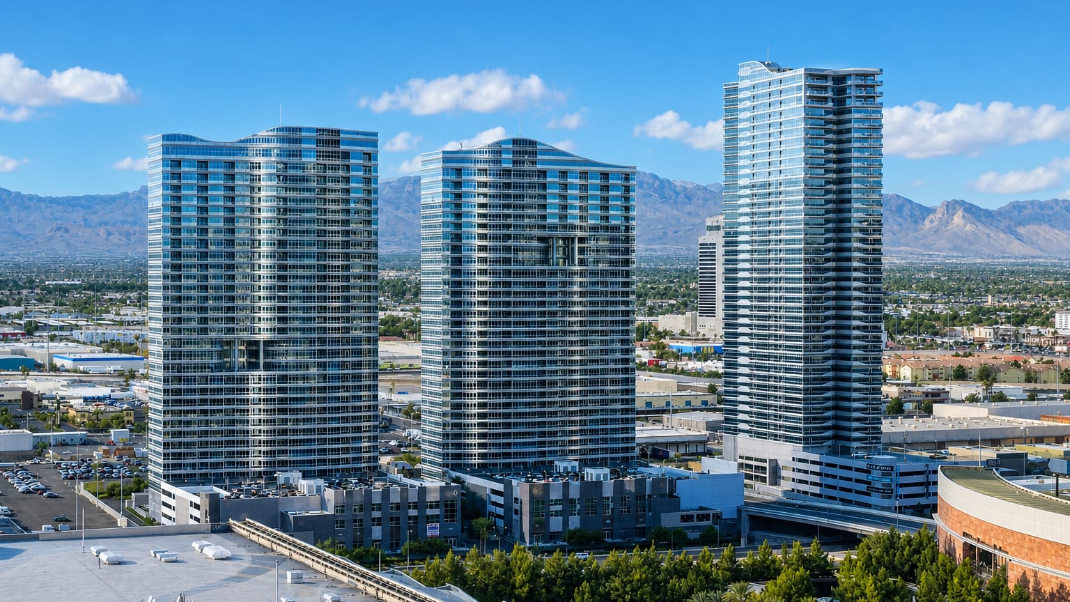 High-rise glass residential towers rising above Paradise, Nevada with desert mountains beyond