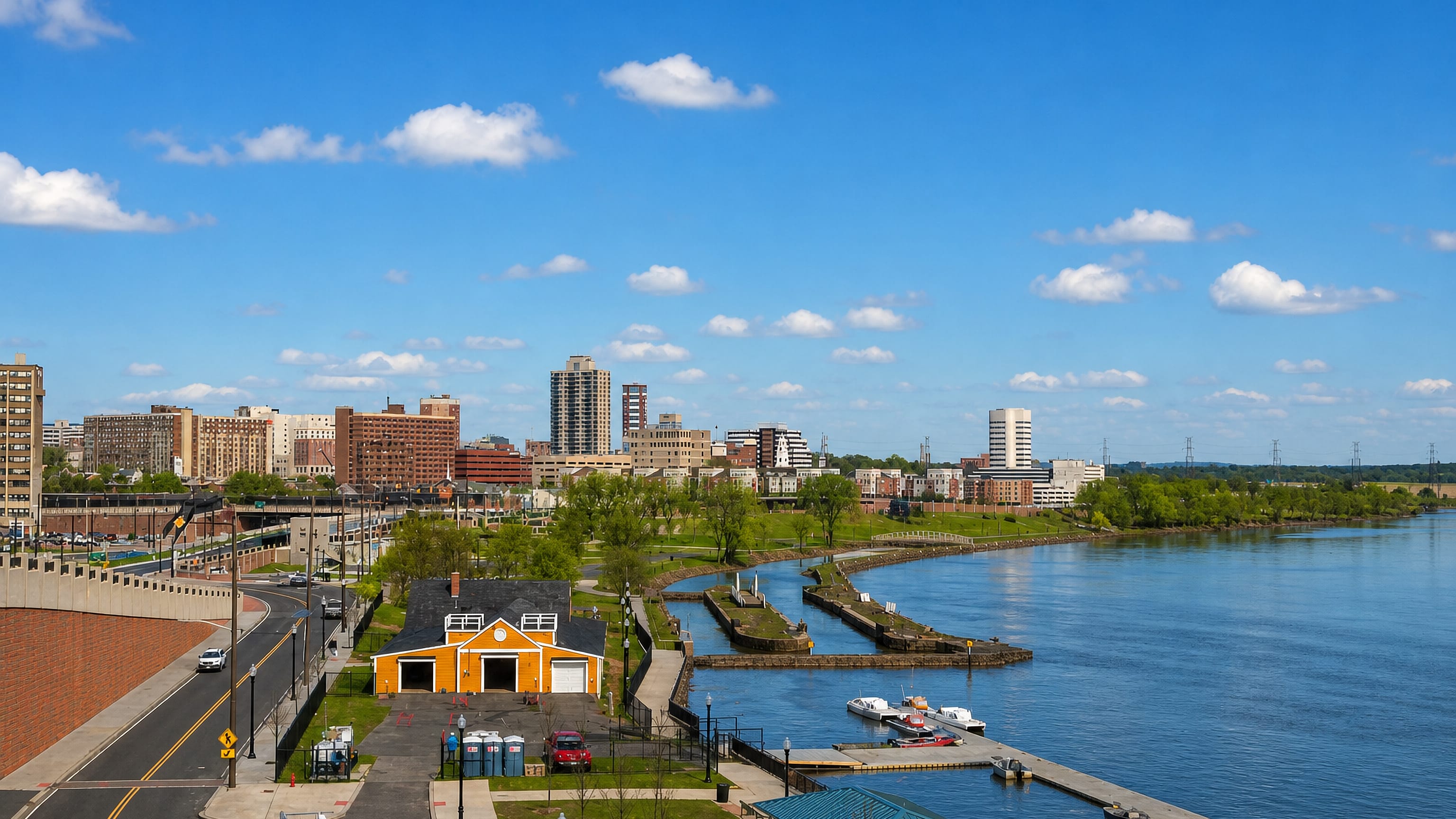 Riverfront park and boathouse on the Raritan below the downtown skyline of New Brunswick, New Jersey.