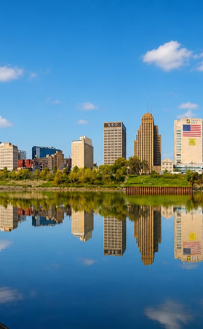 Newark's downtown skyline mirrored in the Passaic River, with the National Newark Building and Art Deco towers.