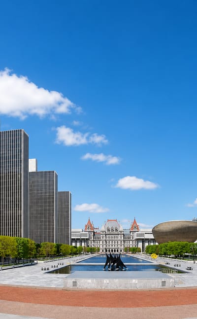 Albany, New York's Empire State Plaza with its agency towers, The Egg, and the State Capitol under a blue sky