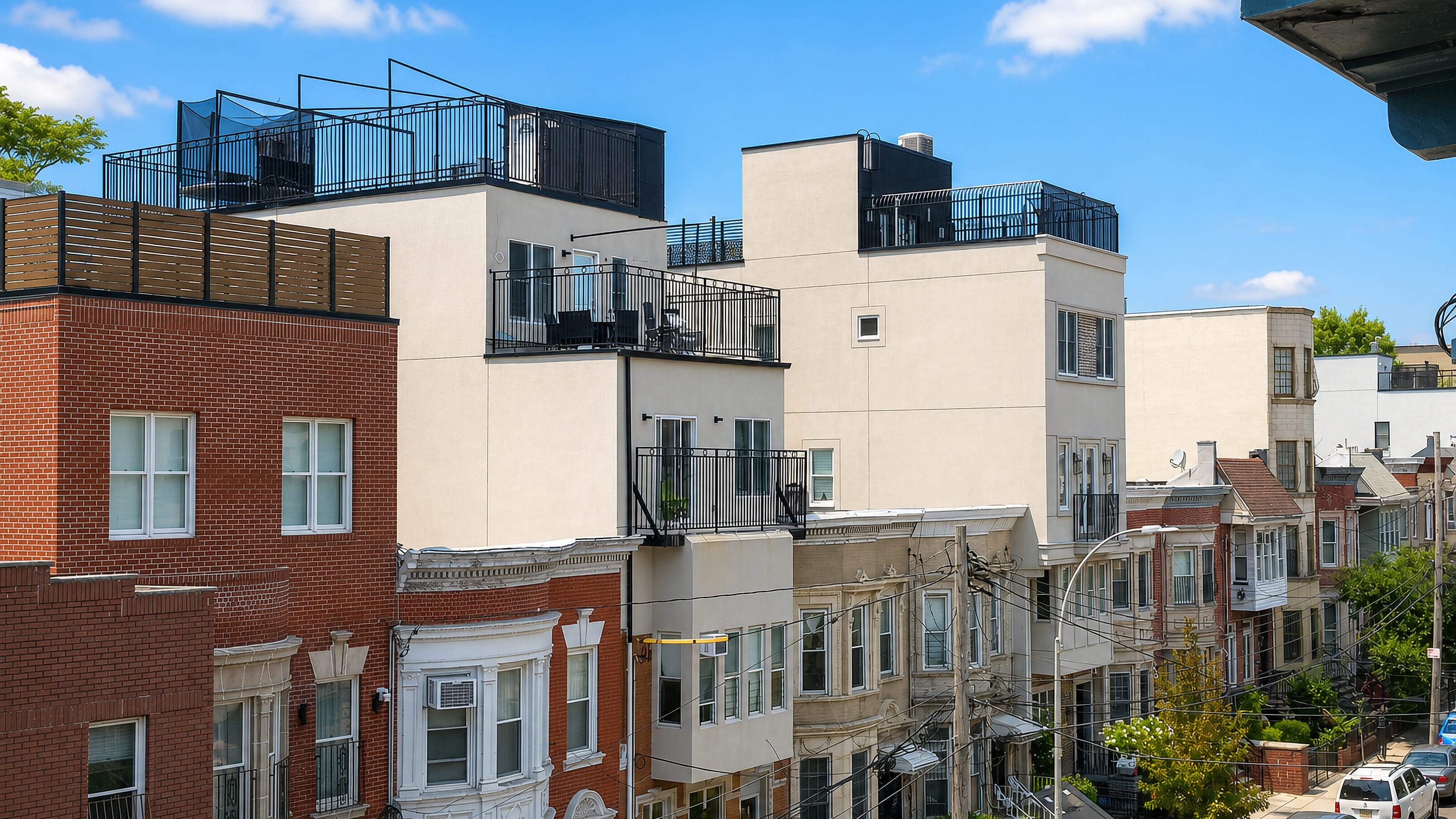 Row houses with roof decks and bay windows lining a residential street in Borough Park, Brooklyn.