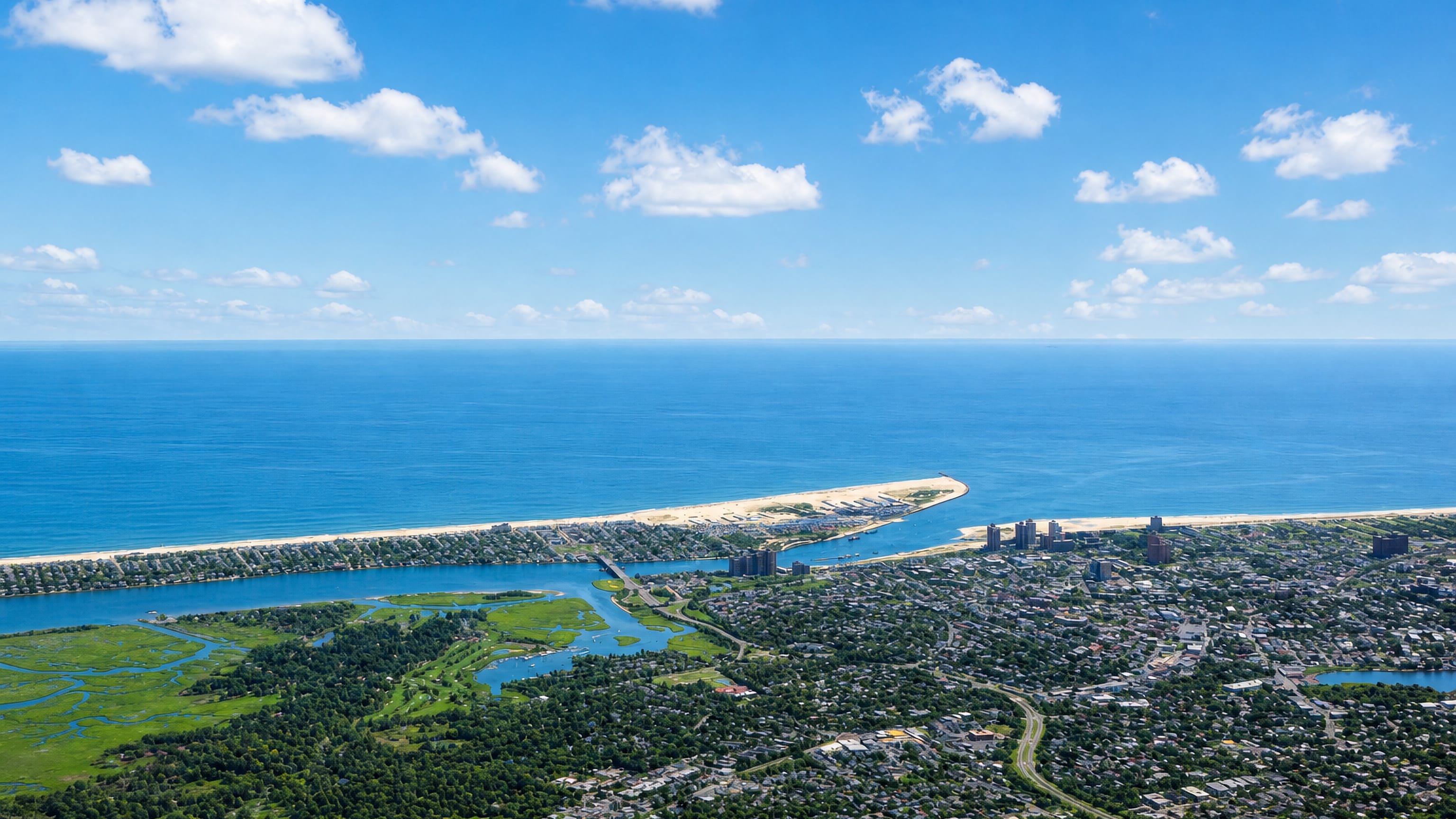 Aerial view of Far Rockaway, New York, its beach peninsula, apartment towers and bayside marshes