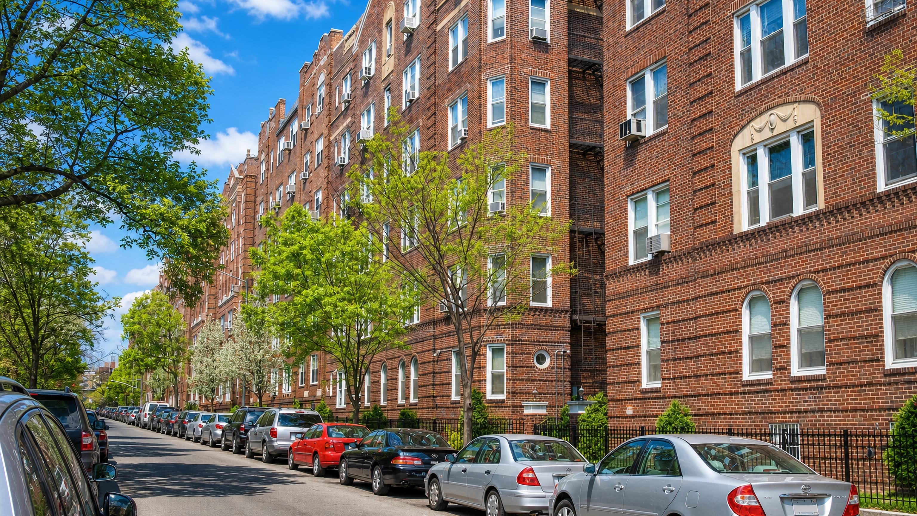 Tree-lined street of prewar brick garden apartments in Jackson Heights, Queens, New York City.
