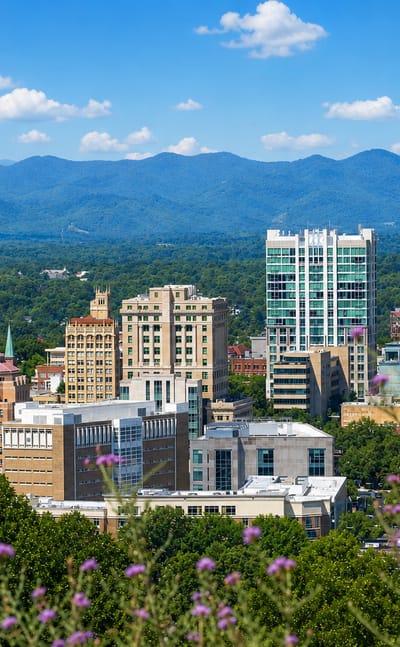Downtown Asheville, North Carolina skyline with its Art Deco City Hall dome before the Blue Ridge Mountains.