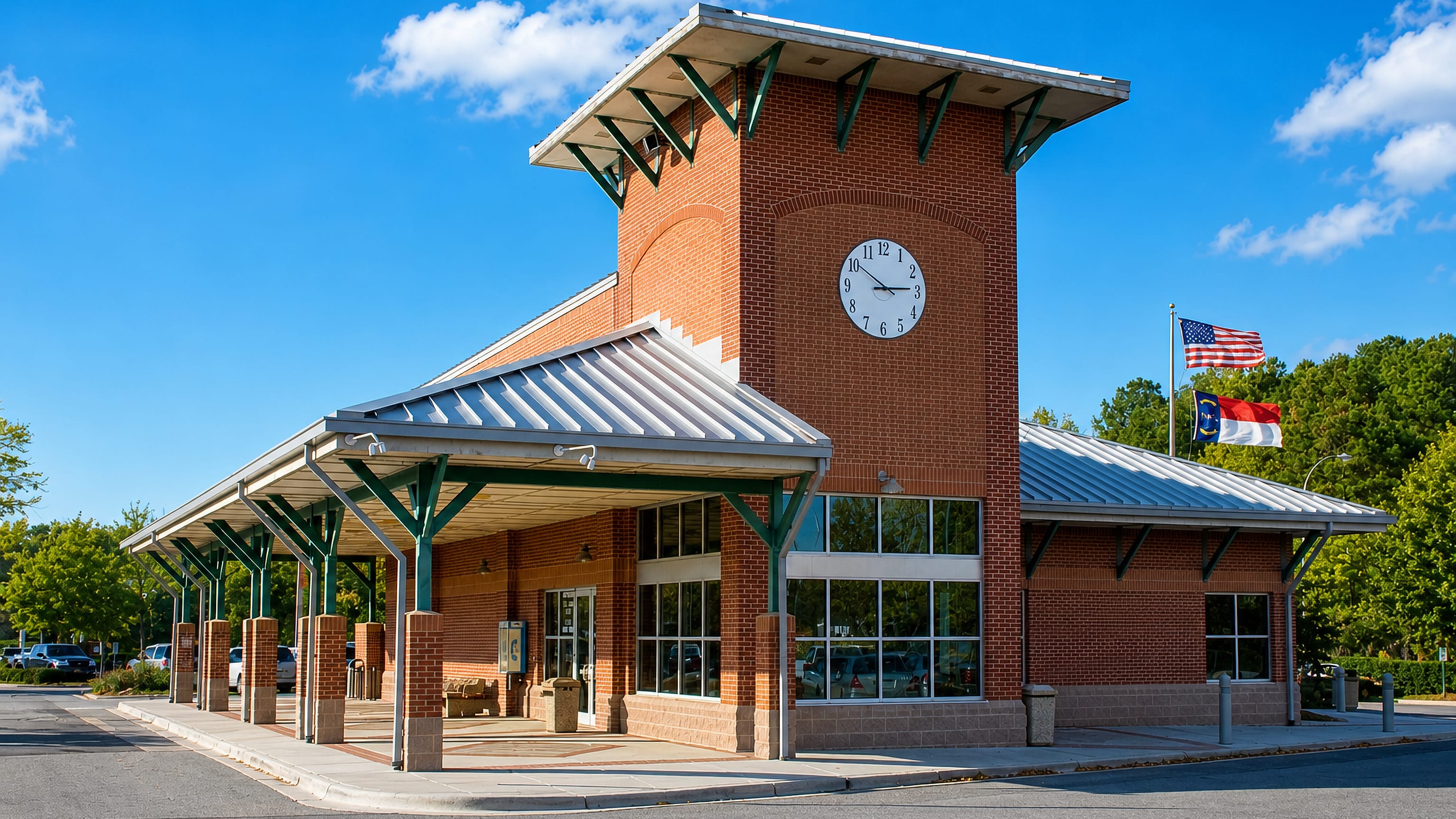 A brick clock-tower building flying US and North Carolina flags in downtown Cary, North Carolina.
