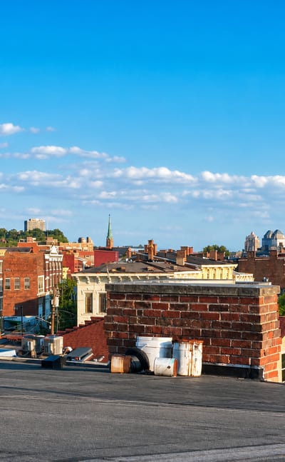 Cincinnati, Ohio rooftops and distant downtown skyline including the crowned Great American Tower on a sunny day