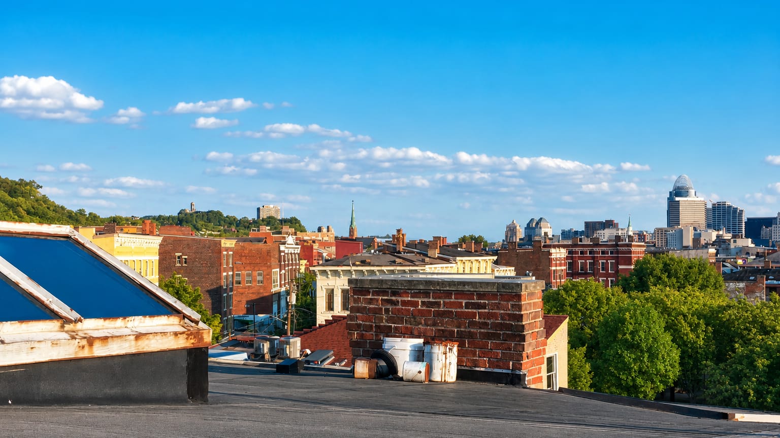 Cincinnati, Ohio rooftops and distant downtown skyline including the crowned Great American Tower on a sunny day