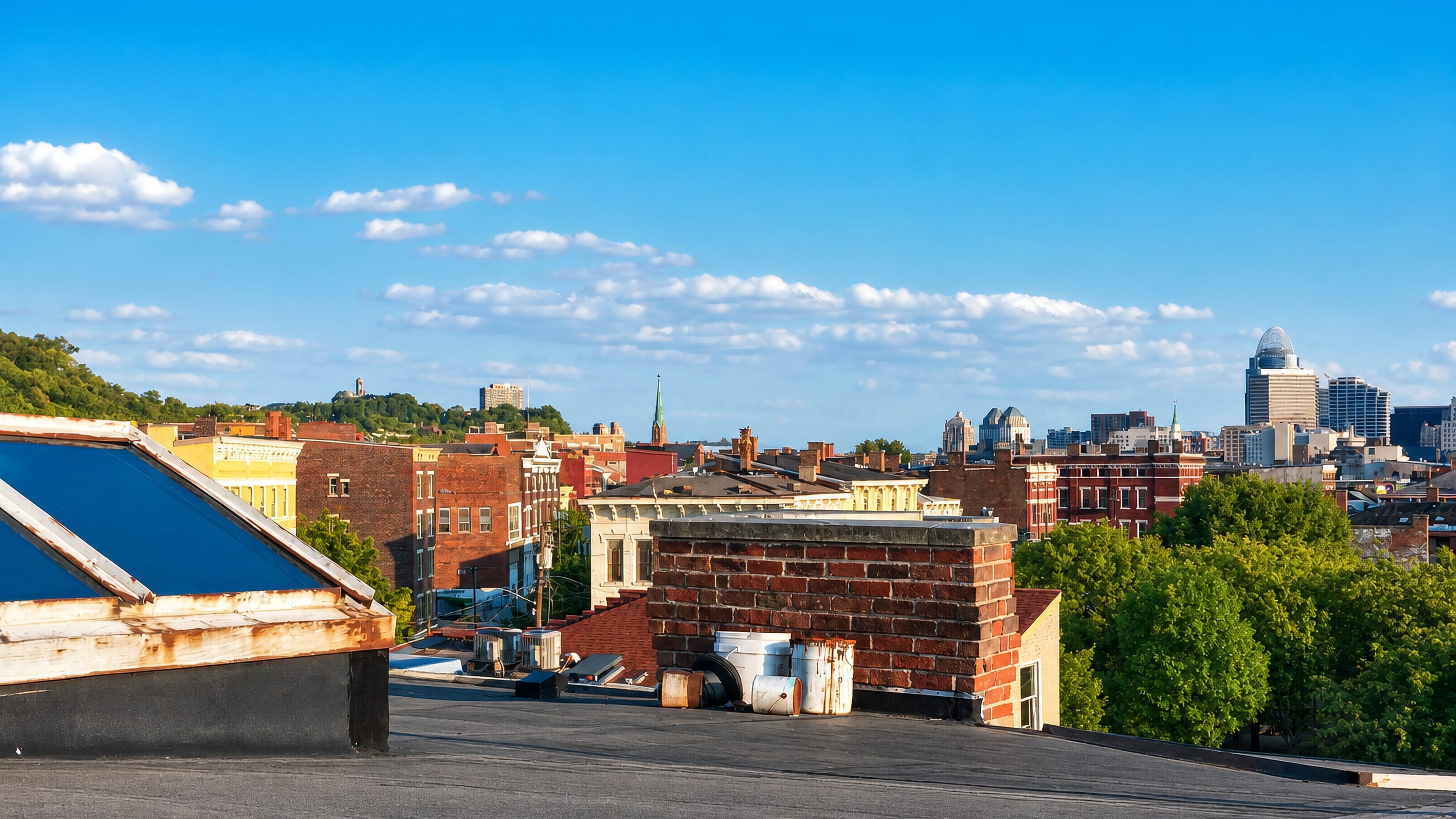 Cincinnati, Ohio rooftops and distant downtown skyline including the crowned Great American Tower on a sunny day