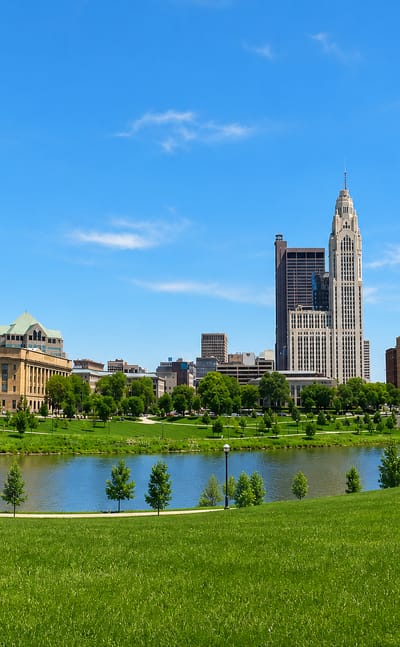 Columbus, Ohio skyline with the LeVeque Tower along the Scioto River and a green riverfront park
