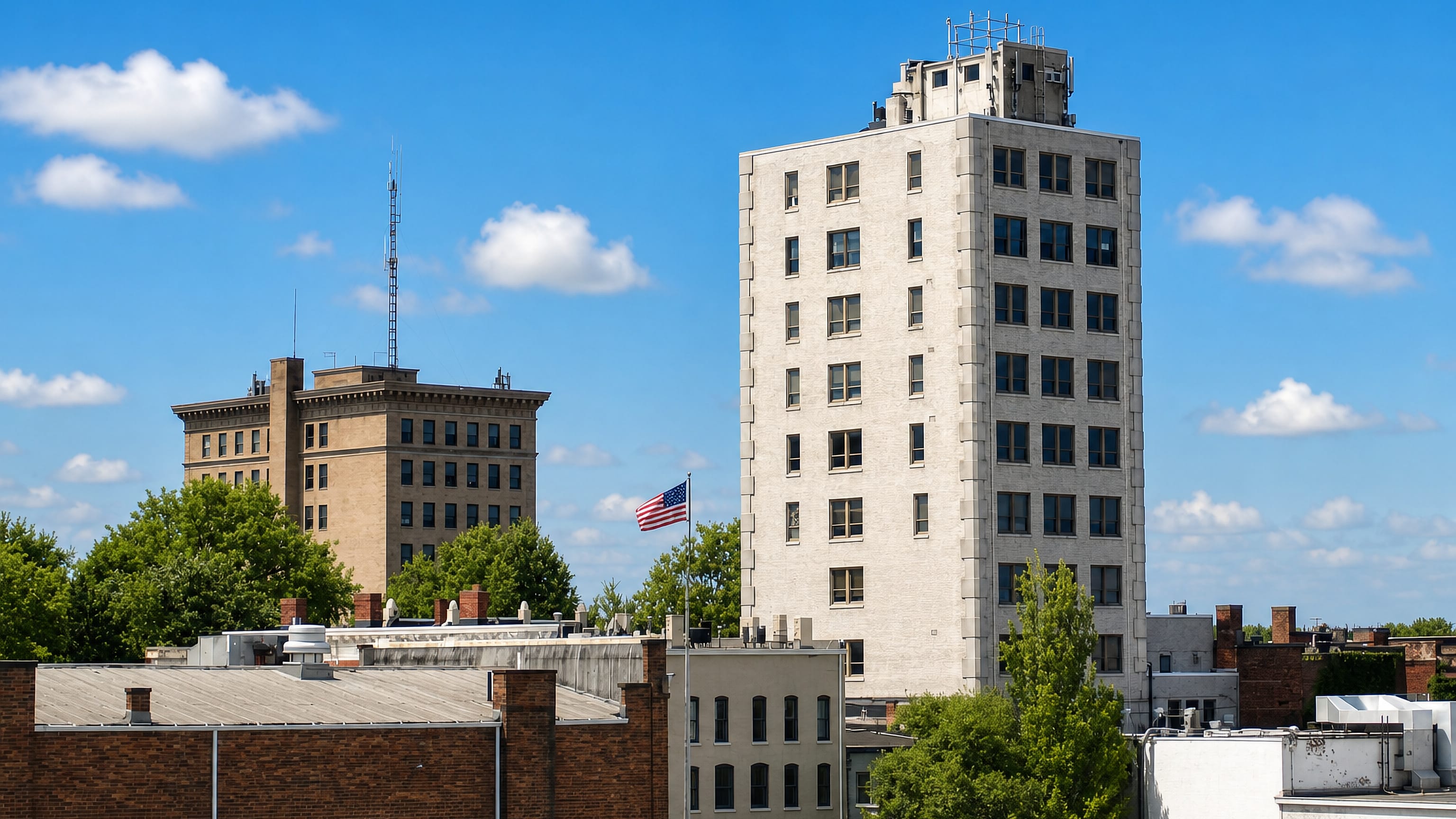 Brick and limestone mid-rise buildings above the rooftops of downtown Elyria, Ohio