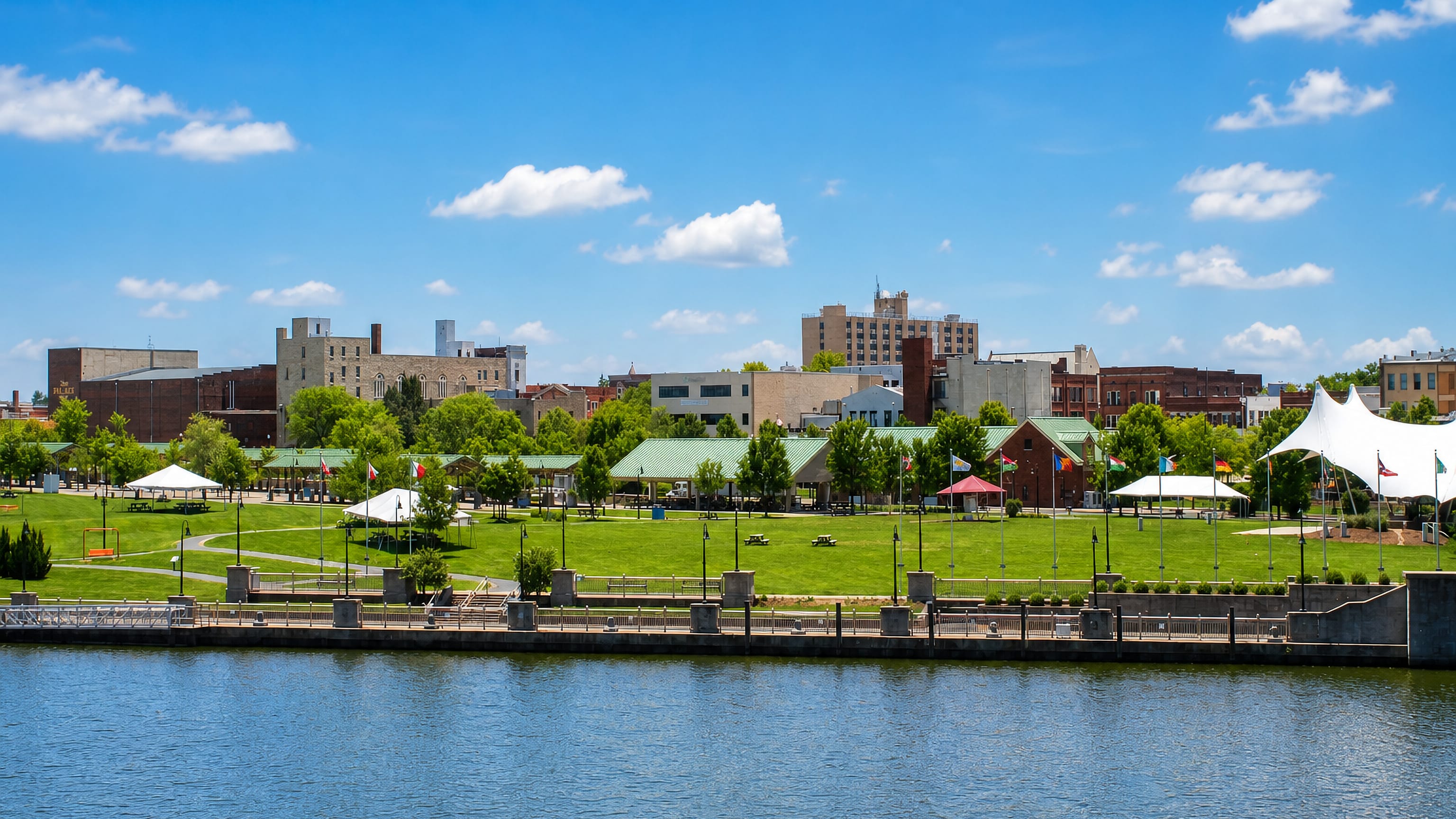 Riverfront park lawn and the low downtown skyline of Lorain, Ohio, seen across the Black River.