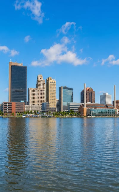 Downtown Toledo, Ohio skyline with its dark tower and blue-glass building across the Maumee River.