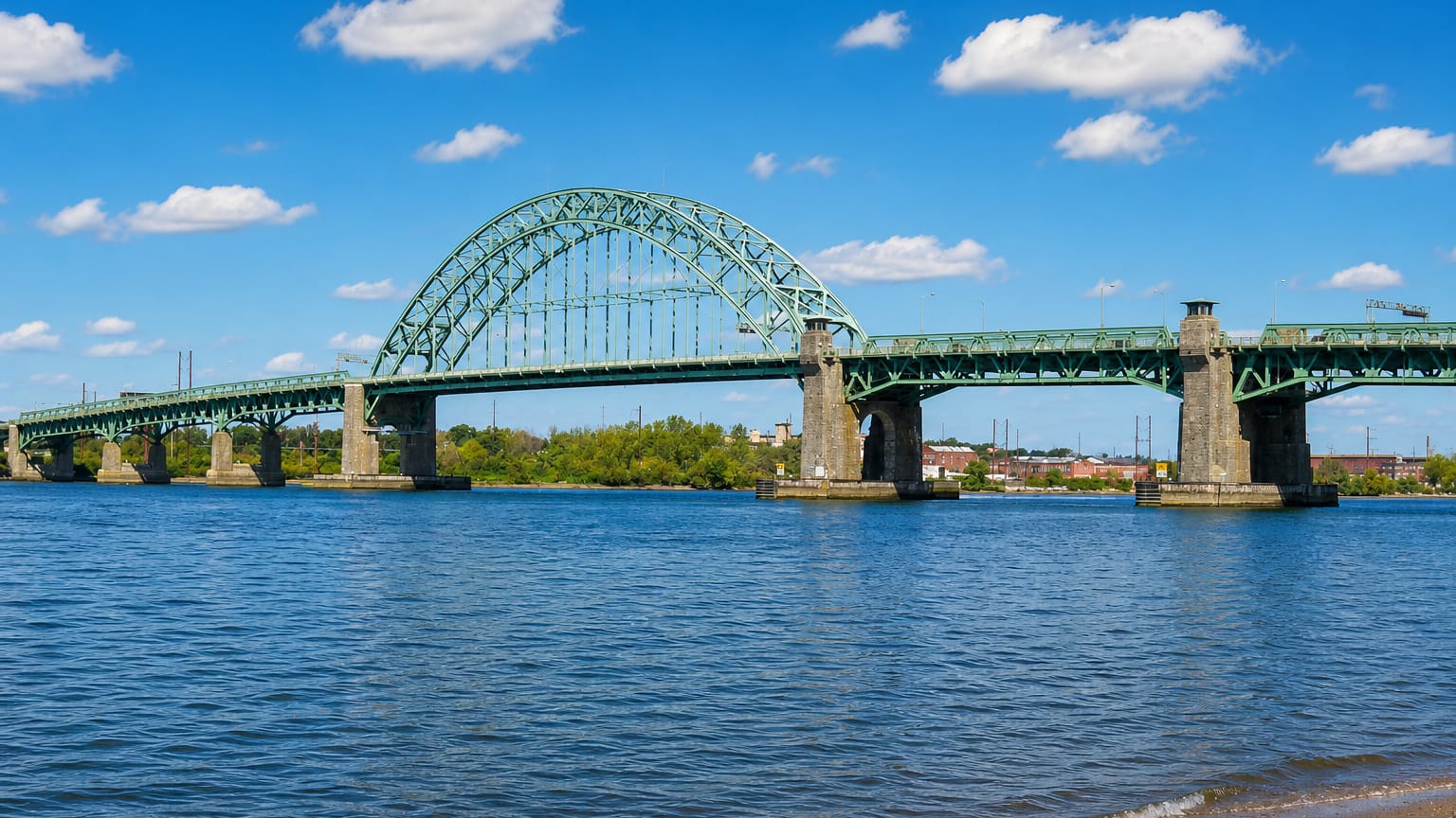 The green steel arch of the Tacony-Palmyra Bridge spanning the Delaware River at Tacony, Philadelphia.