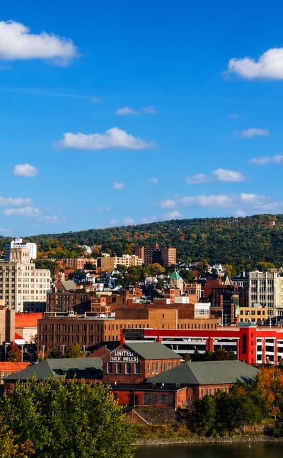 Scranton, Pennsylvania townscape of red-brick mills and downtown buildings against forested autumn hills