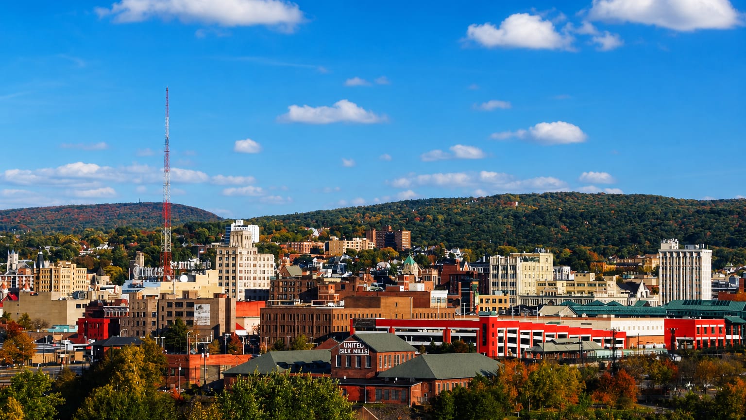 Scranton, Pennsylvania townscape of red-brick mills and downtown buildings against forested autumn hills