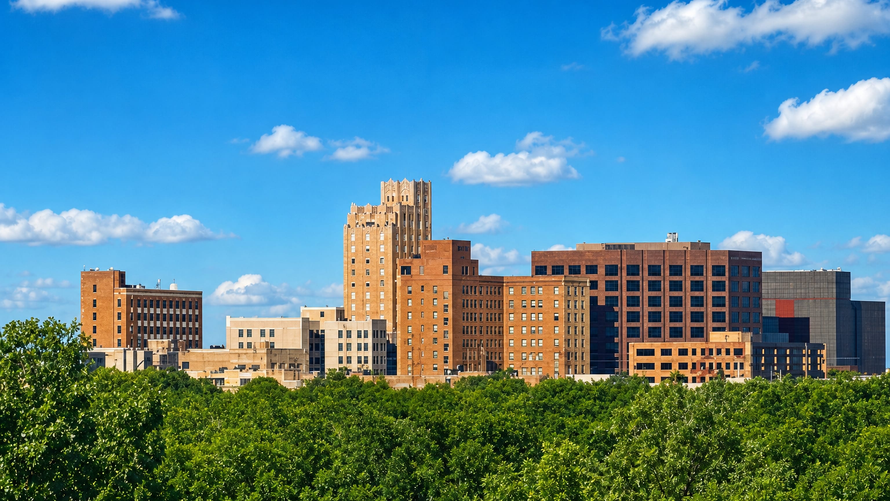 Abilene, Texas skyline of brick mid-rise blocks and an Art Deco tower rising above dense summer treetops