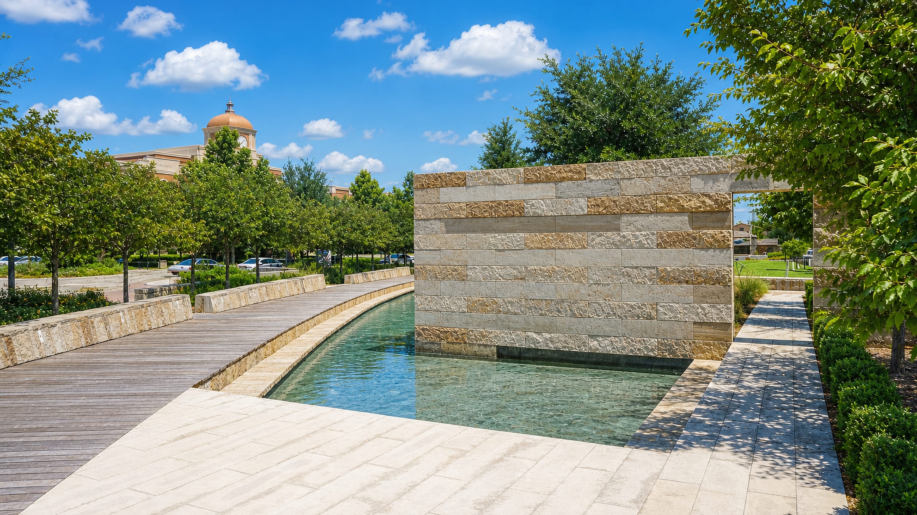 Stone water feature and boardwalk in a landscaped civic plaza in Lewisville, Texas.